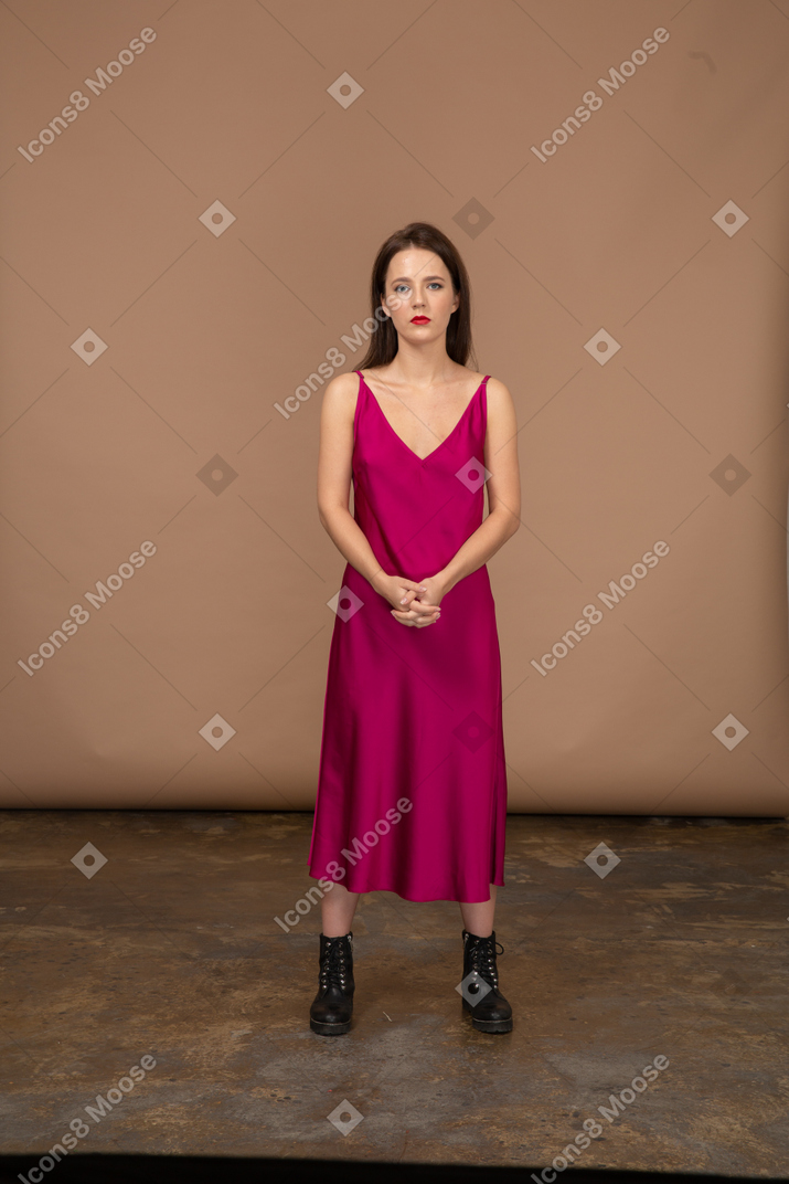 Vista frontale di una giovane donna in un bellissimo vestito rosso che guarda l'obbiettivo