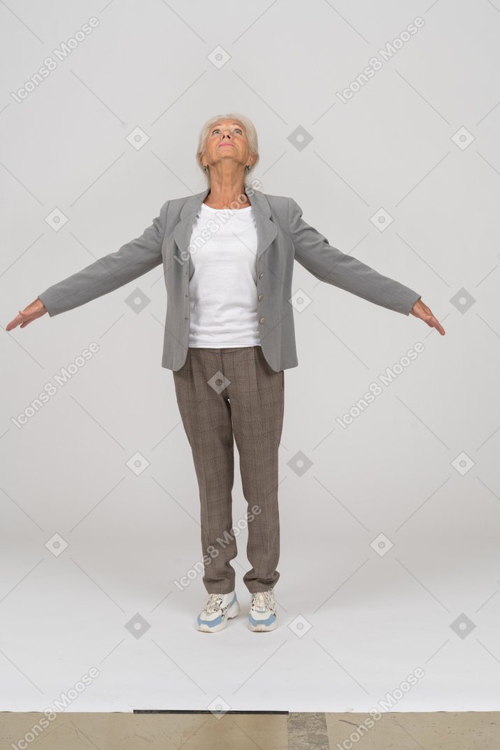 一位穿着西装的老太太站在脚趾上，双臂张开的前视图
