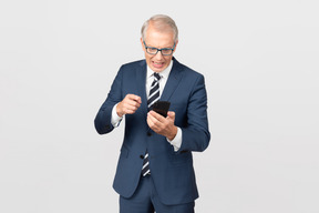Элегантный мужчина средних лет, используя свой смартфон