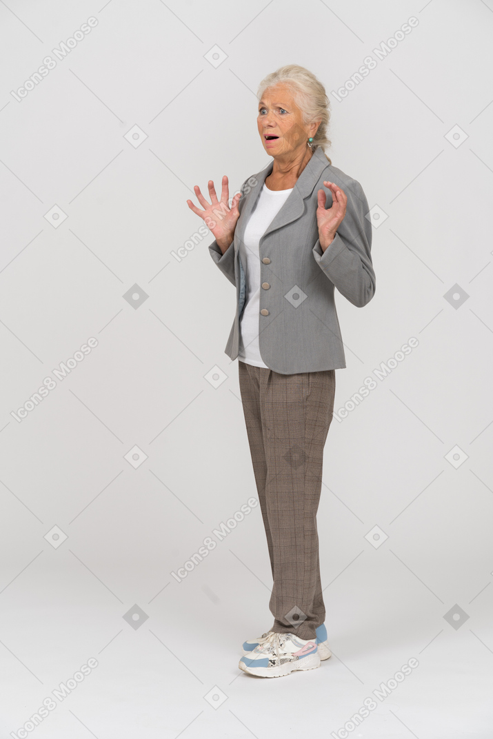 Verängstigte alte dame im anzug, die im profil steht