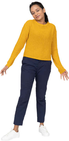Front view of a cute girl in casual clothes posing with outstretched arms