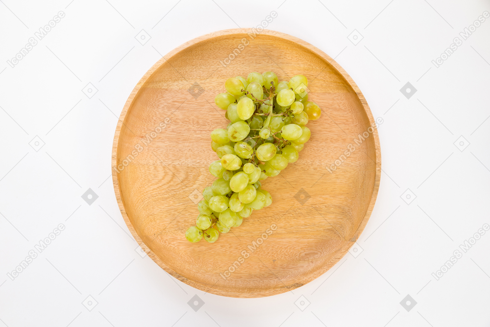 Ramo di uva bianca sul piatto di legno
