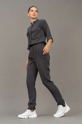 Three-quarter view of a walking young woman in a jumpsuit