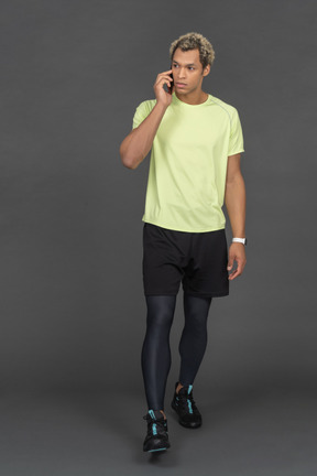 Homme en vêtements de sport parlant au téléphone