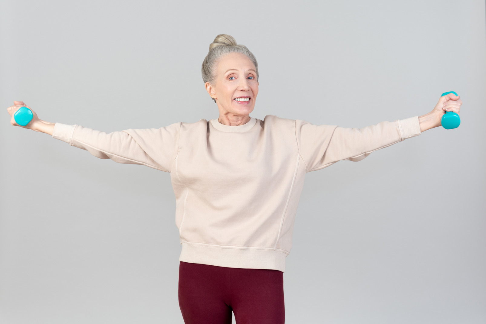 Smiling old woman holding hand weights