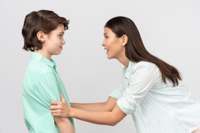 Excited mother grabbing her son's arms