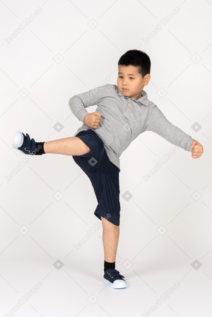 Vista frontal de um menino com a perna para cima