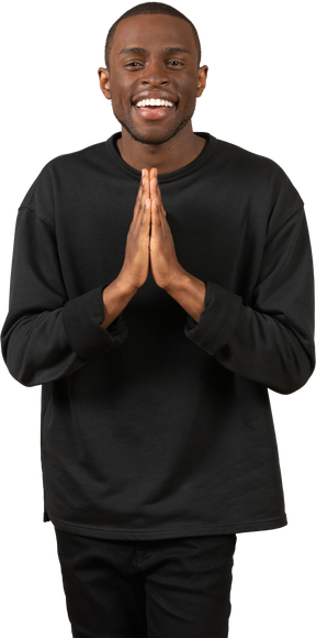 Grateful young man with folded hands