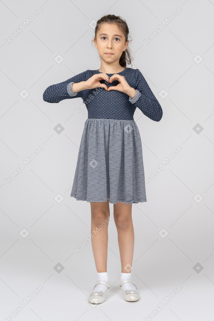 A little girl making a heart with her hands