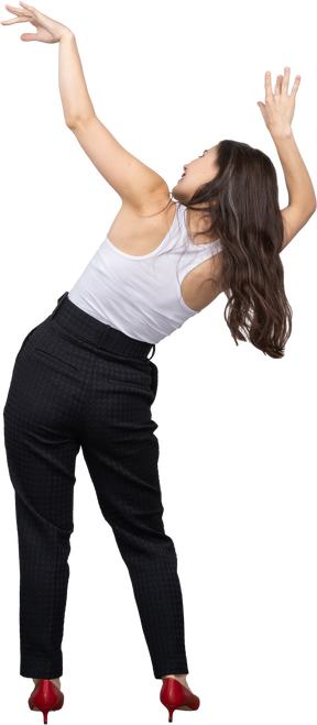 Back view of a young female in office clothing raising hands and tilting body