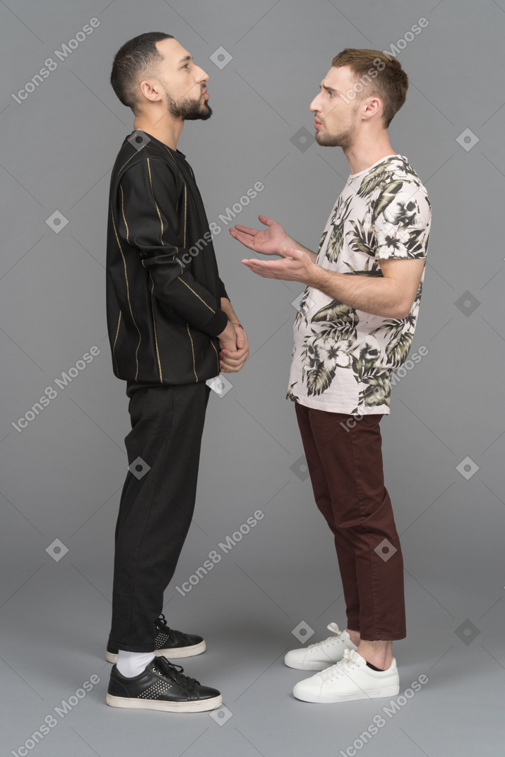 Side view of two young men arguing about something