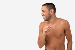 Barechested contented young man laughing