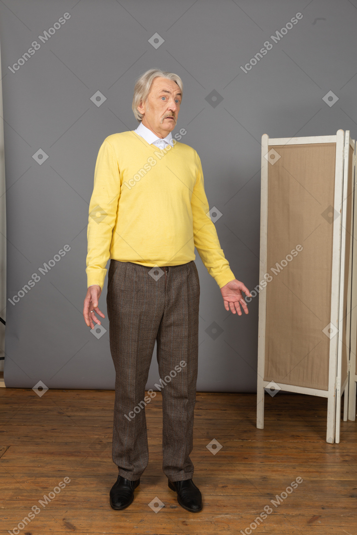 Front view of a questioning old man turning his head