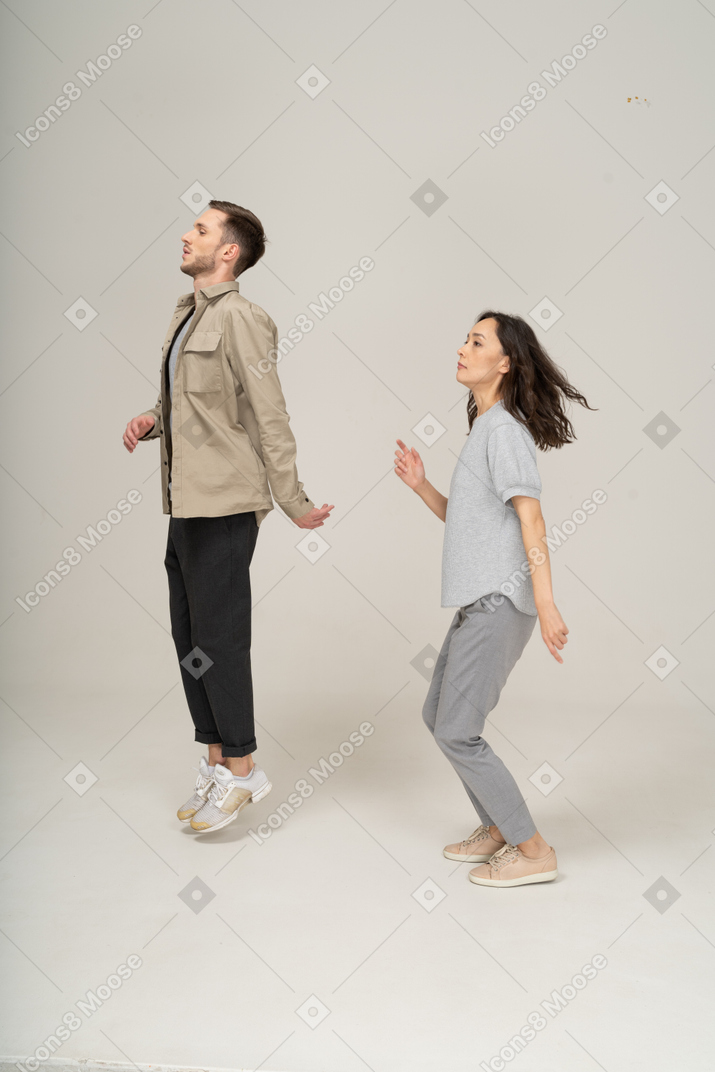 Side view of young active couple jumping