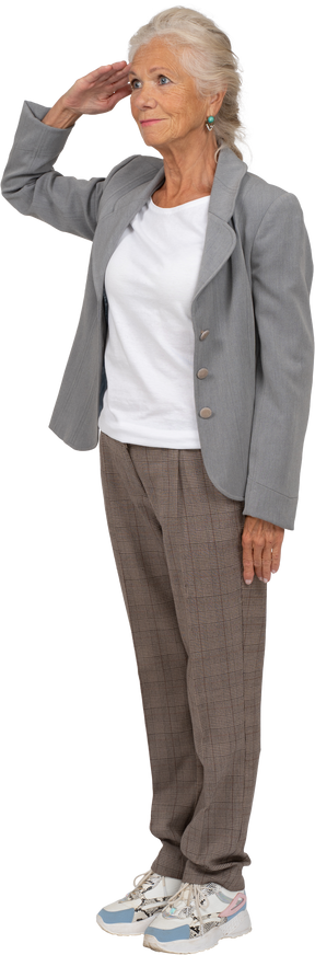 Vista lateral de uma senhora idosa de terno saudando com a mão