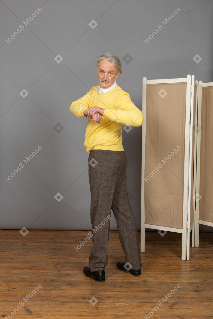 Vista posterior de un anciano haciendo ejercicio haciendo rotación