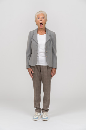 一位身穿西装、张大嘴巴站立的老妇人的前视图