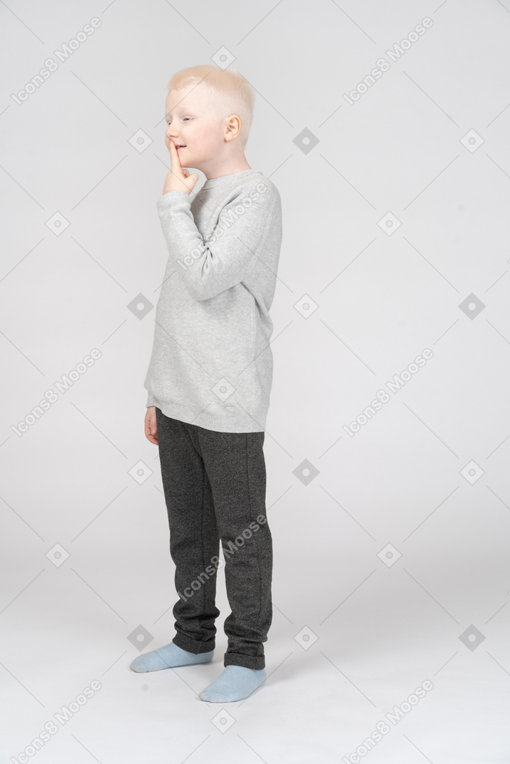 Mischievous boy putting finger up to lips