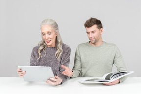 Anciana y joven pasando por un libro juntos