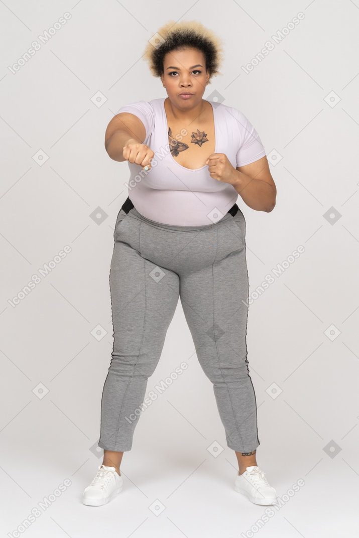 Серьезная черная женщина занимается боксом