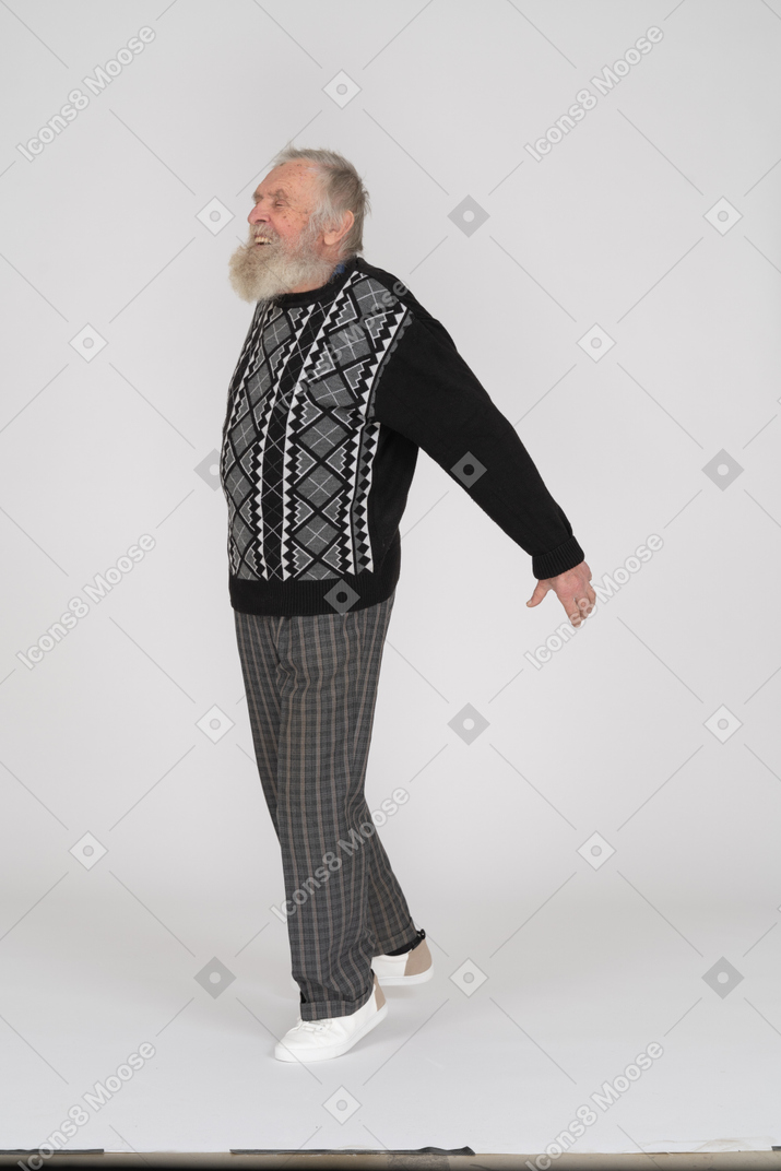 Smiling old man standing on his tip toe with his hands behind him