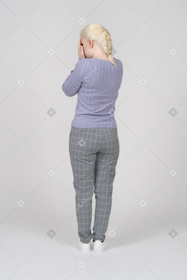 Back view of a woman covering her face