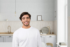 Joven alegre en el fondo de la cocina