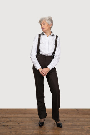 Vista frontal de uma senhora insatisfeita com roupas de escritório, de mãos dadas