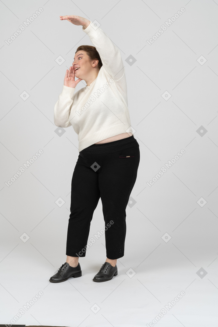 Vista lateral de uma mulher rechonchuda em roupas casuais com o braço levantado