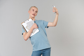 Süßer junger androgyner typ in einem hellblauen t-shirt und blue jeans, auf dem weg zum college