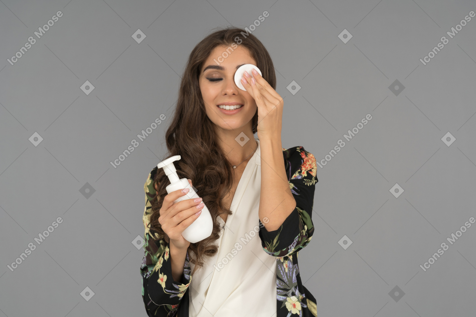 Cheerful turkish woman using cotton pad to remove eye makeup