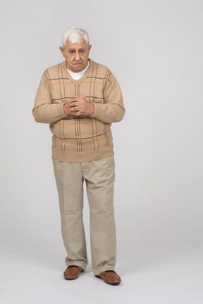 Front view of a thoughtful old man in casual clothes