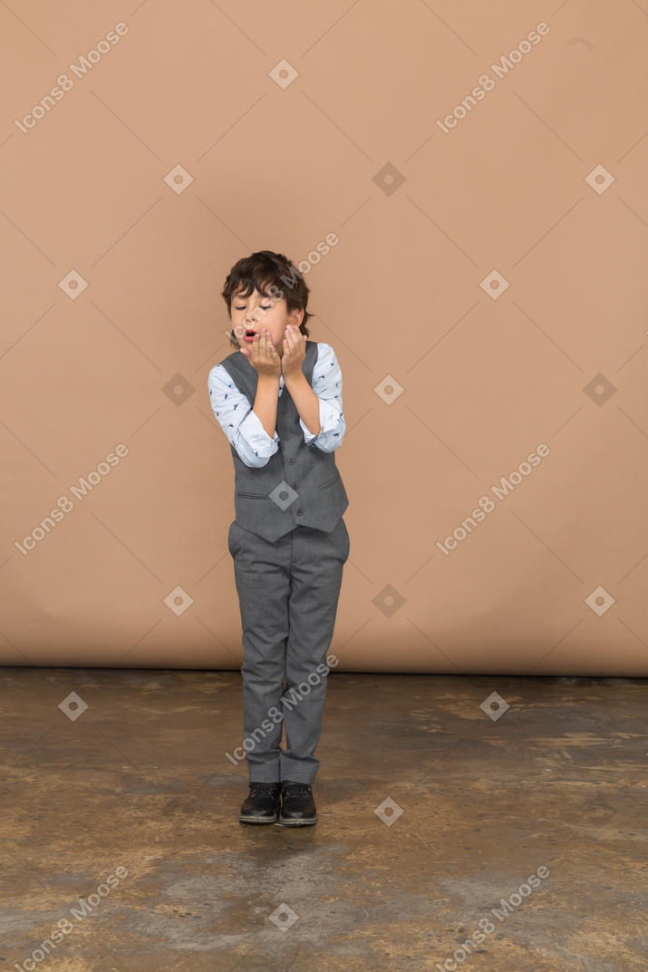 Vista frontal de um menino emocional de terno cinza