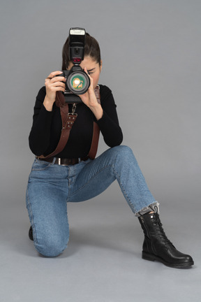 Young woman getting down on her knees to take pictures