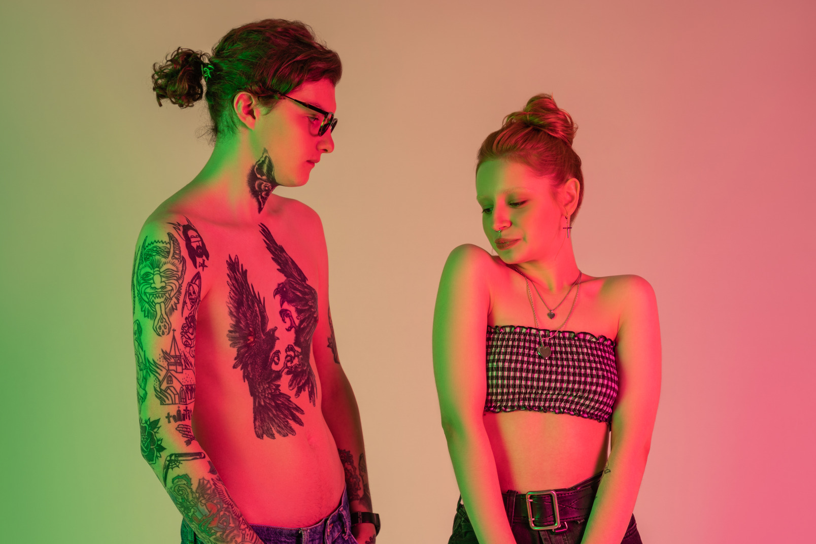 Teen couple in light clothes among green and pink neon