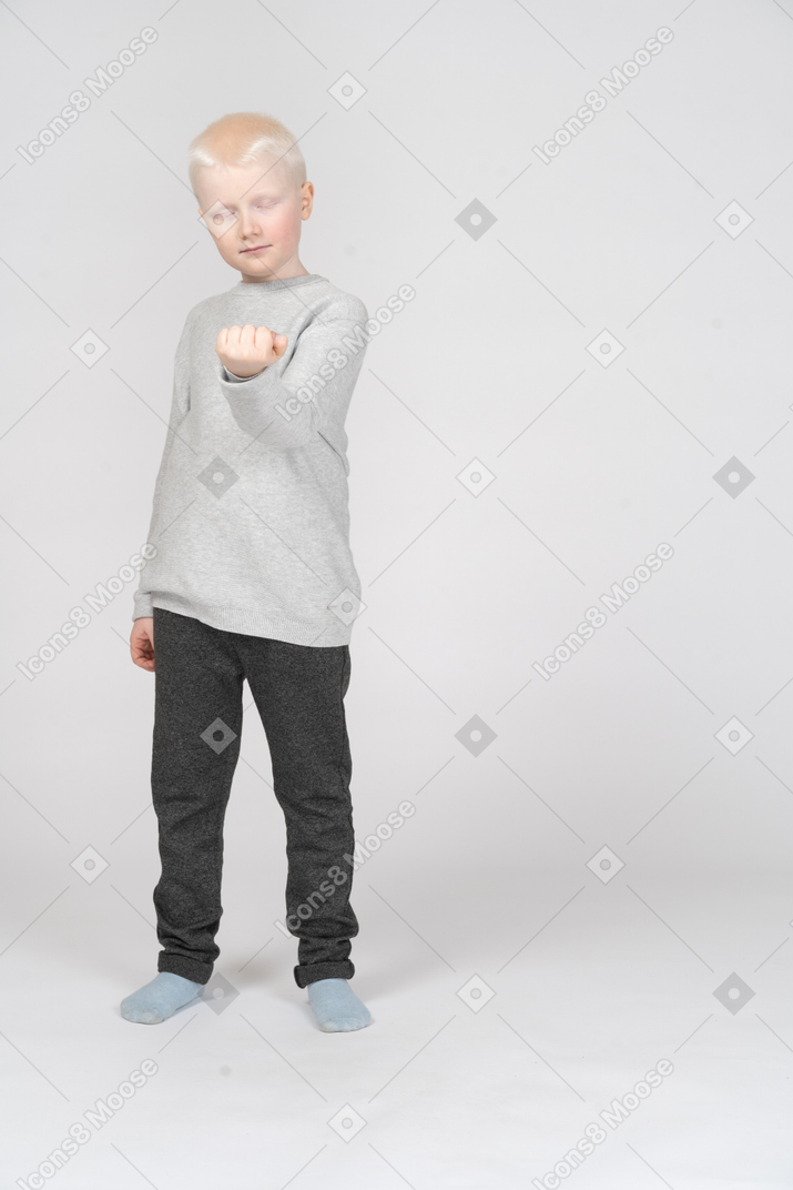 Boy with closed eyes showing his clenched fist