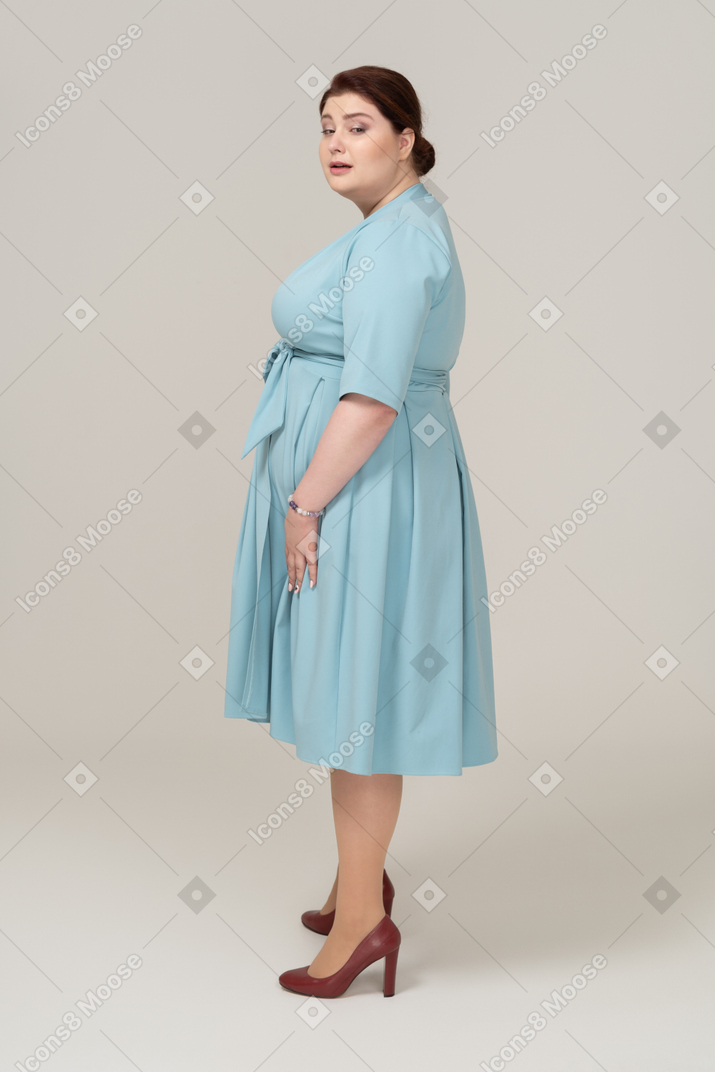 站在侧面的蓝色连衣裙的女人