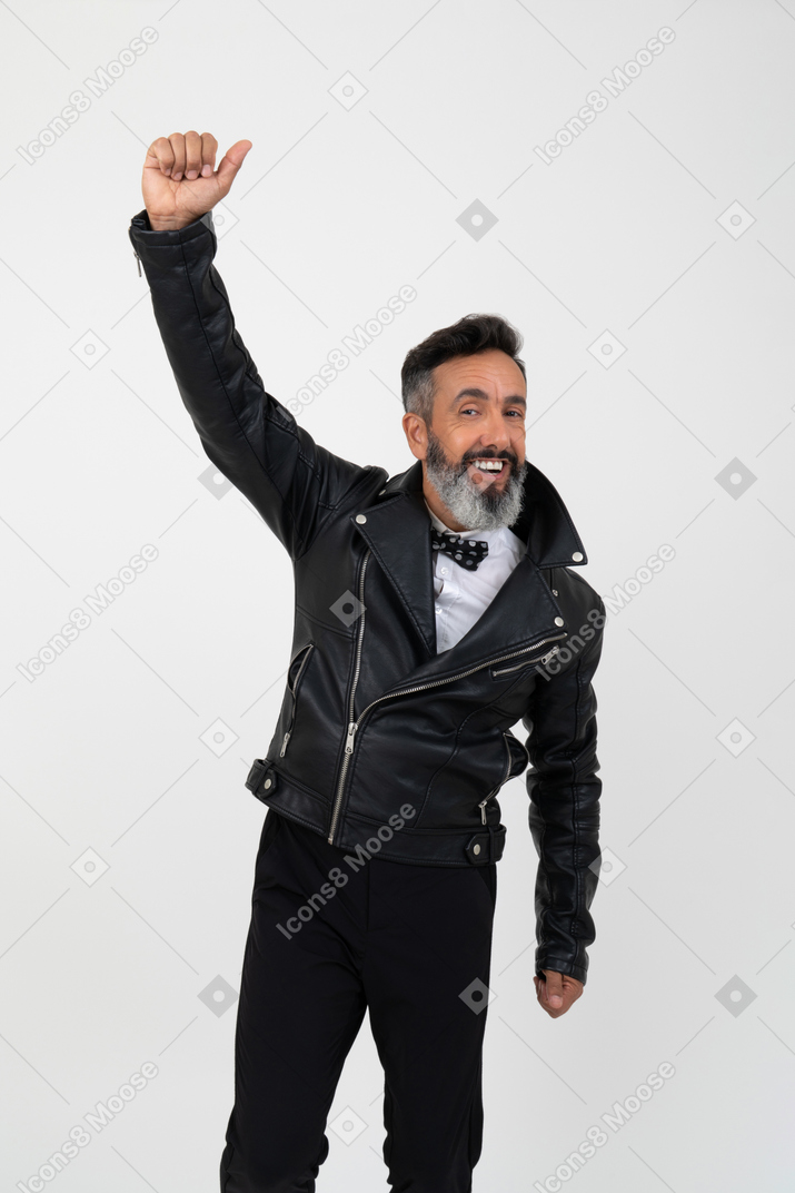 Contented mature man wearing leathe jacket and holding his one hand up