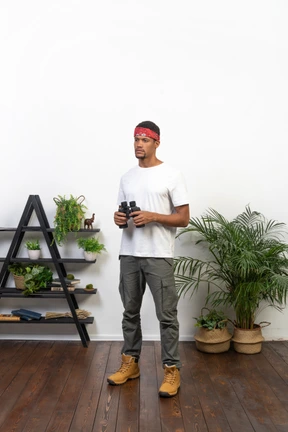 Good looking young man holding binoculars