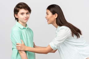 Excited mother grabbing her son's arms