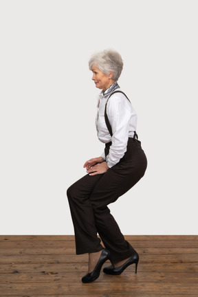 Vue latérale d'une femme en tenue de bureau faisant un demi-squat