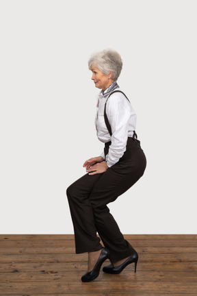 Side view of a woman in office clothes doing half squat