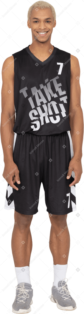 Front view of a smiling young male basketball player standing still