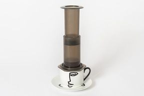 Aeropress on white cup on white background