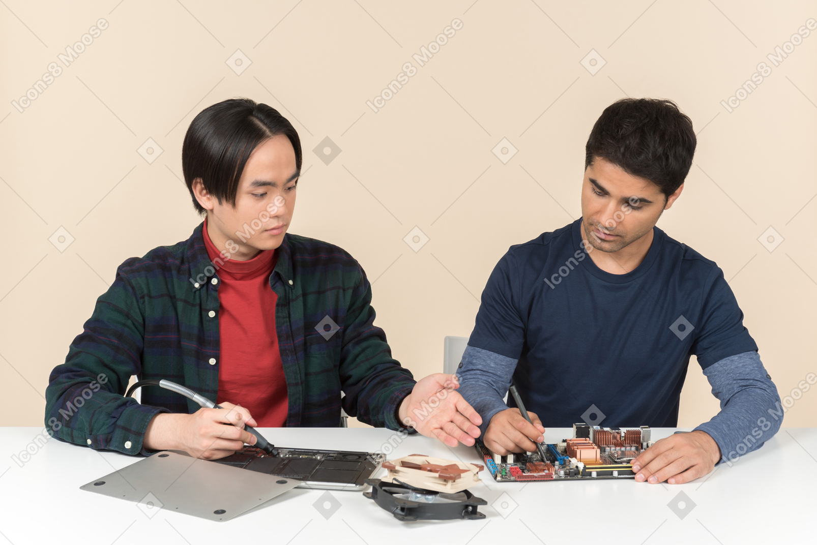 Zwei junge geeks mit einigen details auf dem tisch, die einige probleme haben