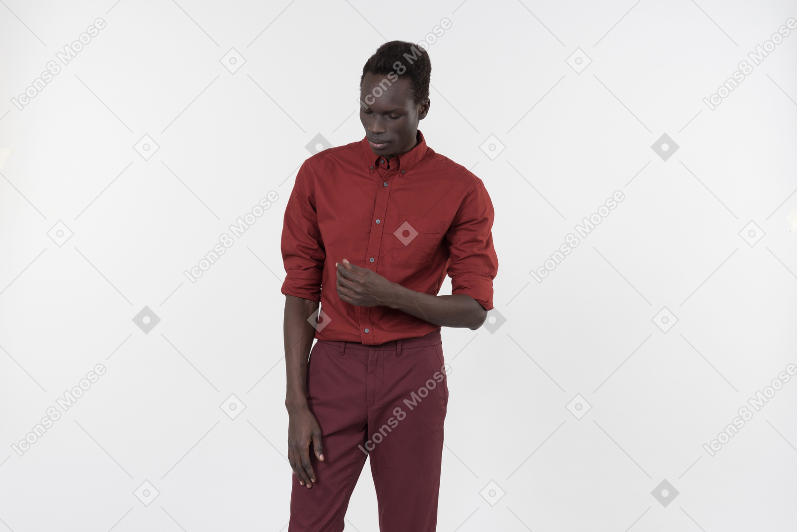 롤업 소매와 어두운 빨간색 바지가 흰색 배경에 혼자 서있는 빨간 셔츠에 젊은 흑인 남자