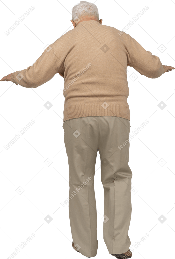 Vue arrière d'un vieil homme en vêtements décontractés marchant avec les bras tendus