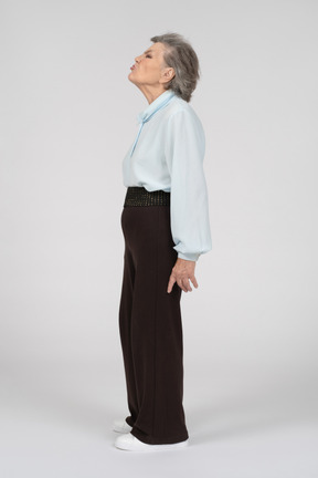 Vista lateral de una anciana haciendo una mueca de disgusto