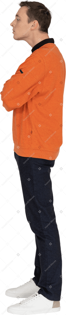 Junger mann im orangefarbenen sweatshirt stehend