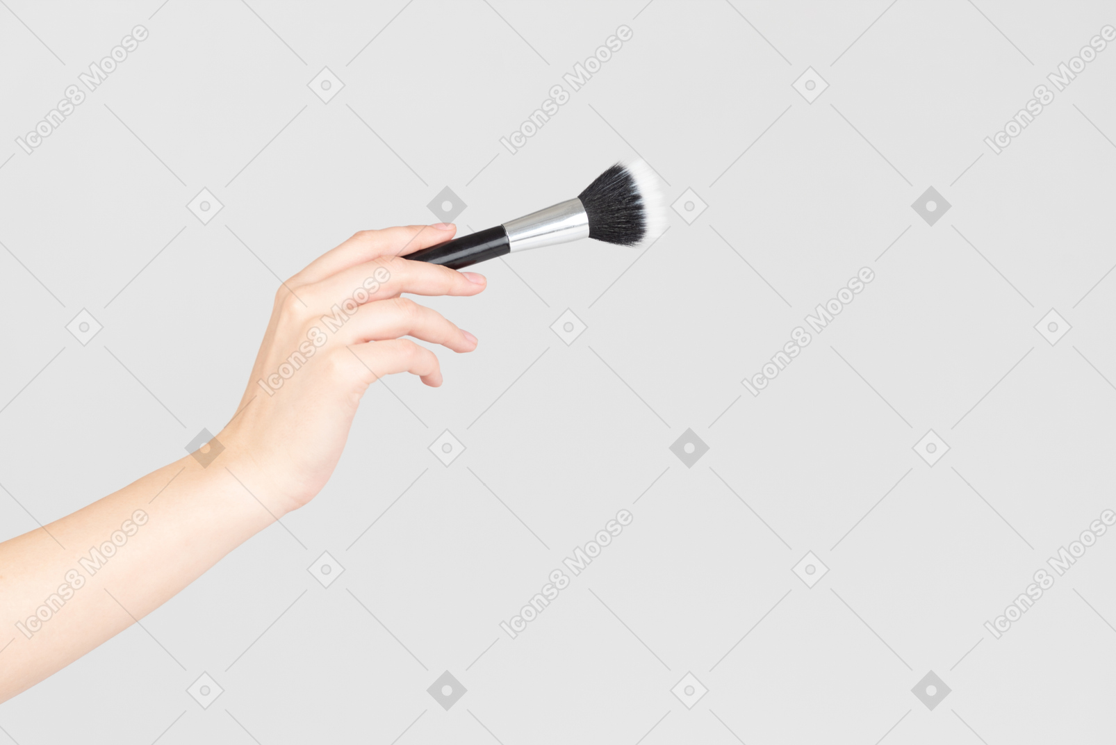 Mano femenina con pincel de maquillaje de cara